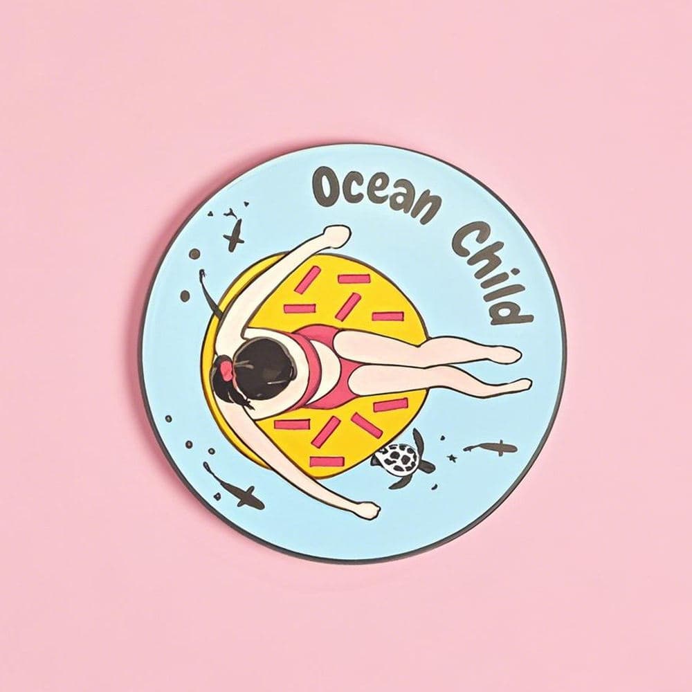 Round custom enamel fridge magnet with an ocean swimmer illustration