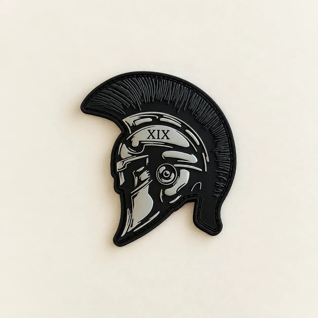 Black and grey PVC helmet-shaped patch with raised outlines