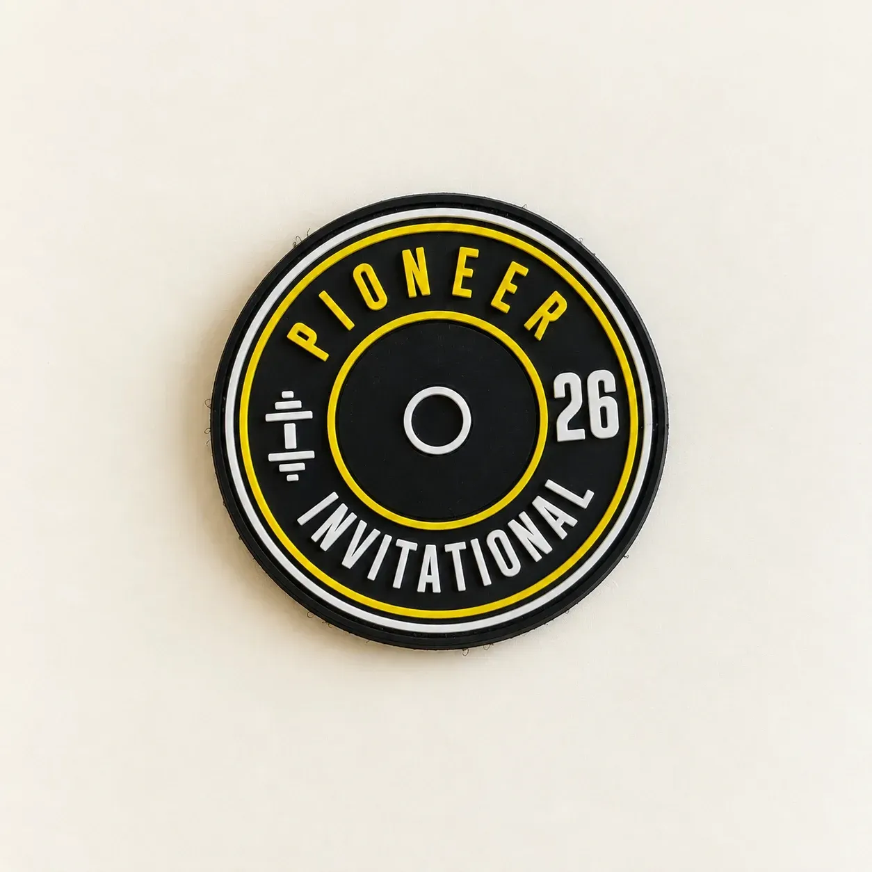Round black PVC Pioneer Invitational patch with raised yellow and white lettering