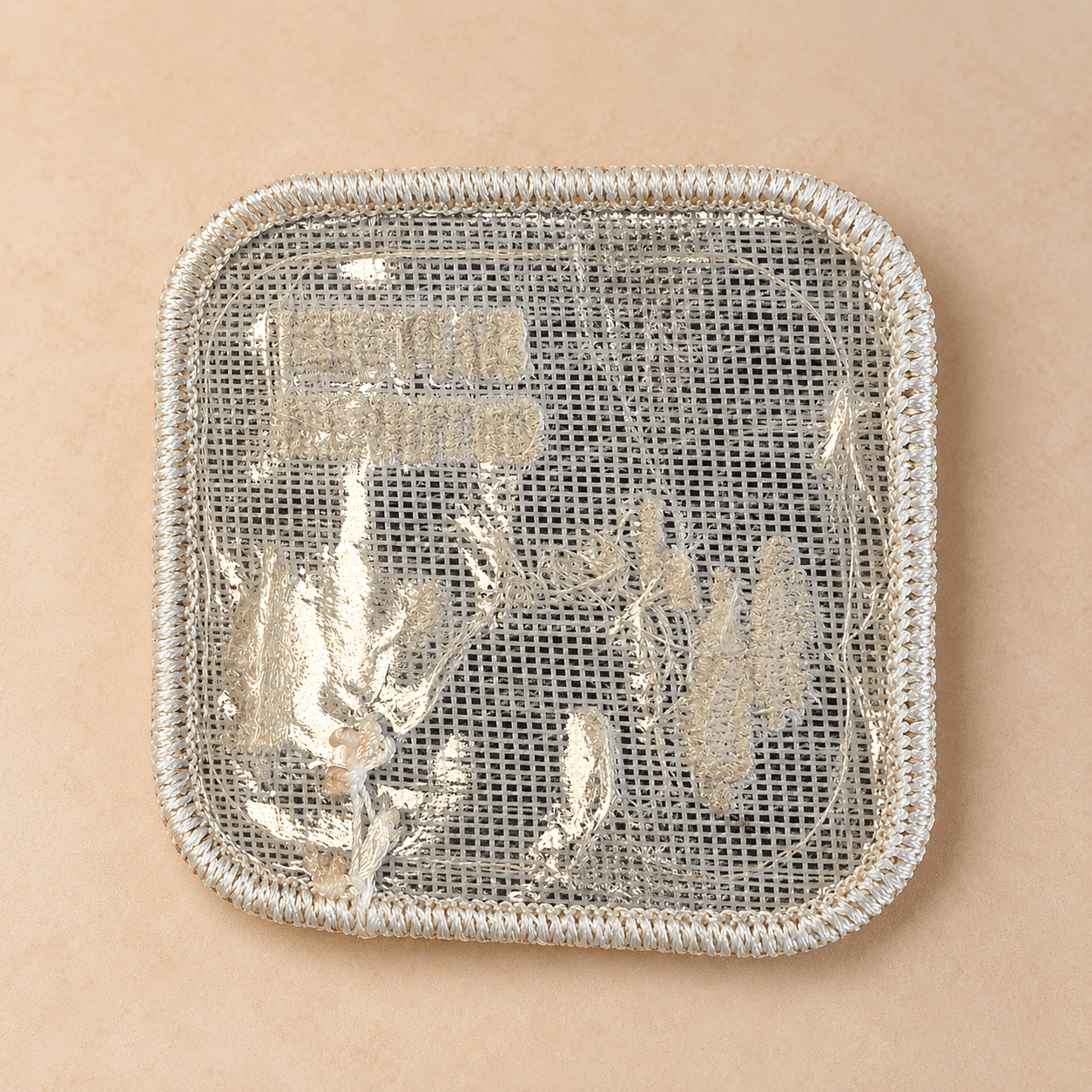 Reverse of an embroidered patch with iron-on backing