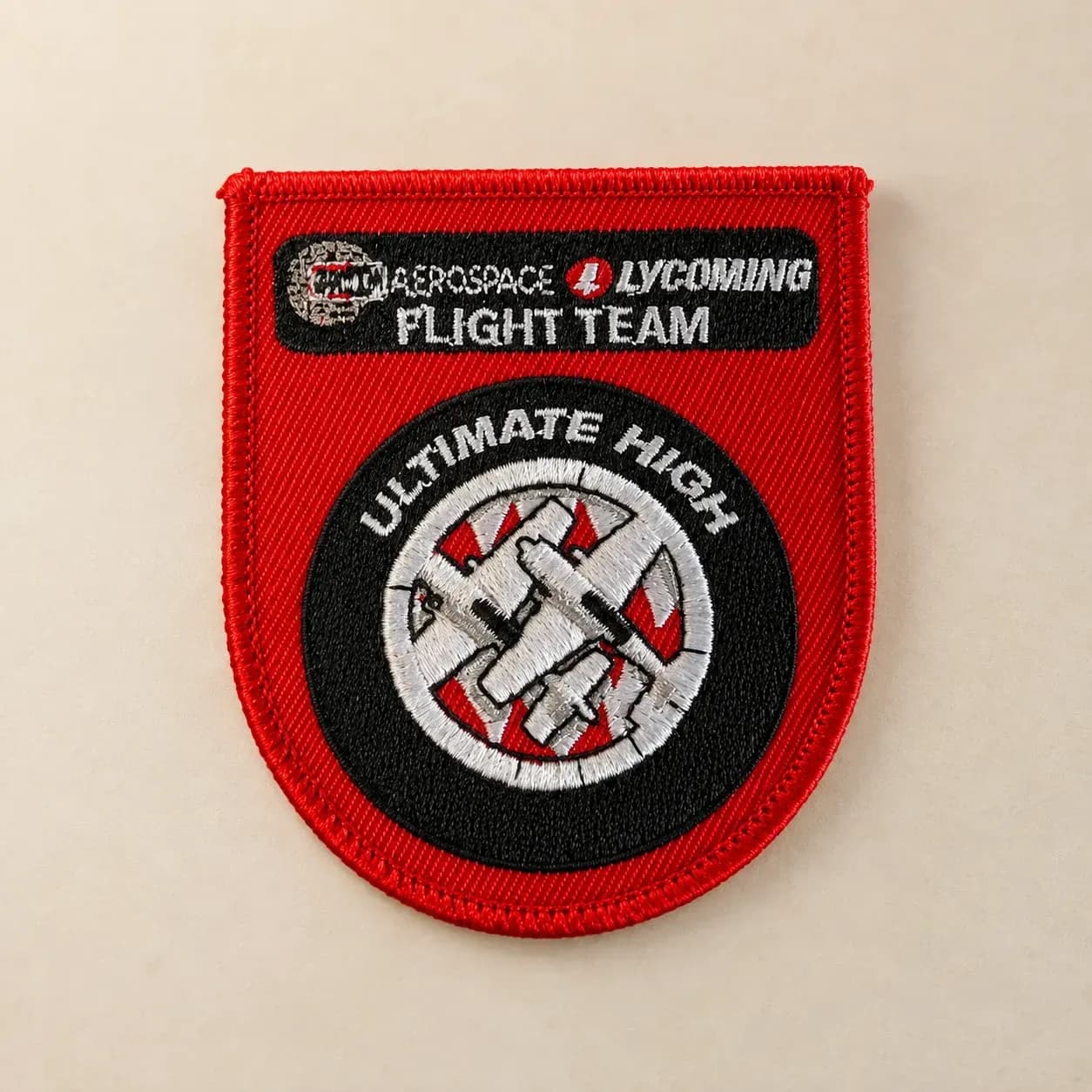 Embroidered red flight-team patch with raised stitching and aircraft detail