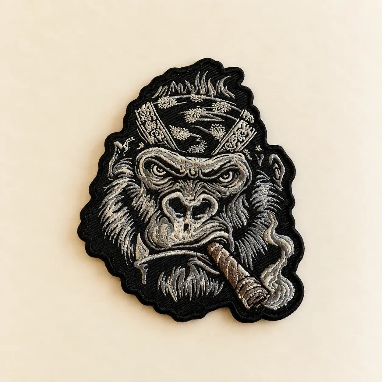Custom-shaped embroidered gorilla patch with fine light-coloured stitching on black fabric