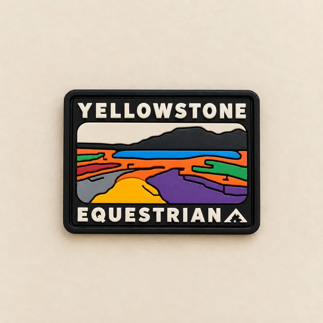 PVC Yellowstone Equestrian patch with raised white lettering and a colourful moulded landscape, photographed on a cream background