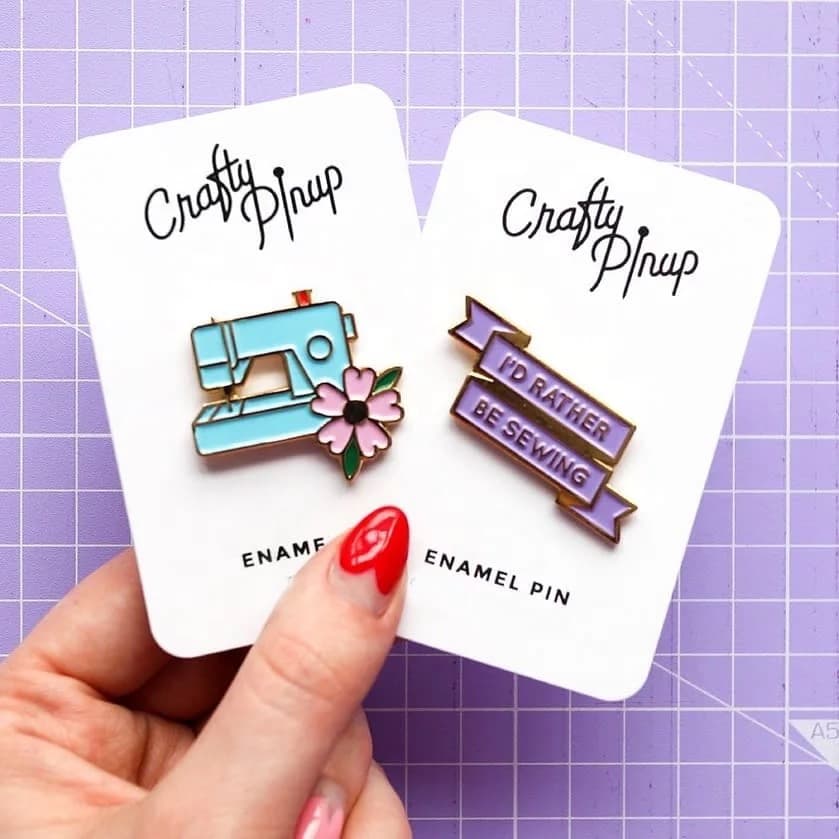 Soft enamel pin badges from the live page: card backing