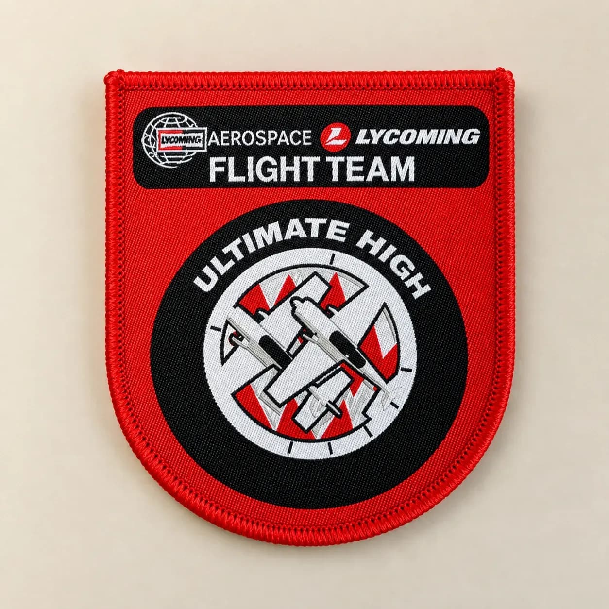 Woven version of the same red flight-team patch, showing finer lettering and aircraft outlines
